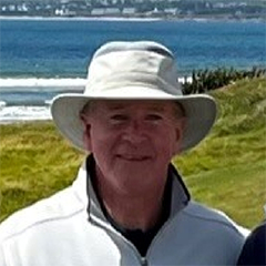 close up of man in a group on a golf course near the sea