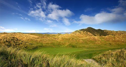 dunes and fairways under blue skies