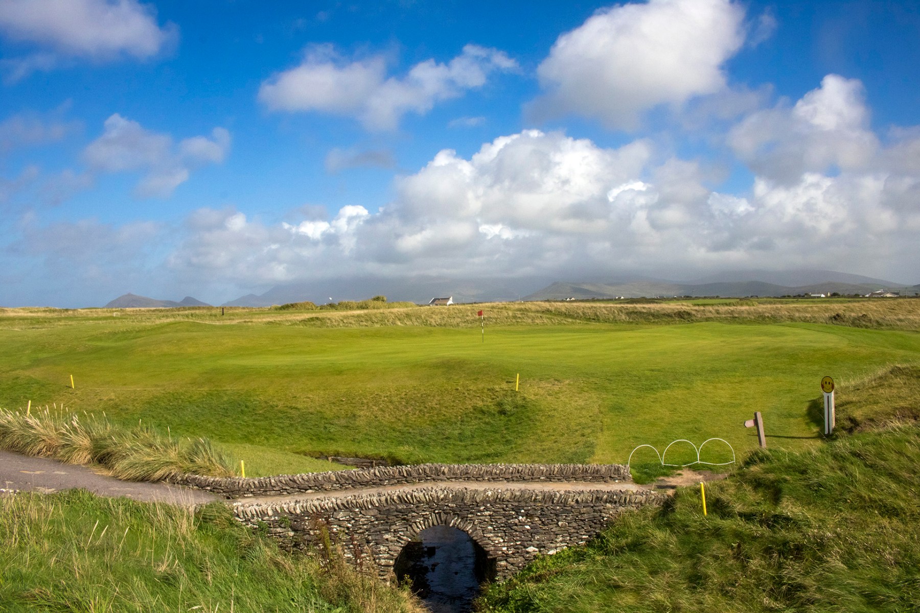 golf course with traditional bridge and blue sky