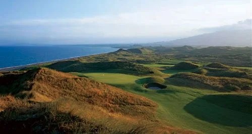 european golf club course with sea to the left