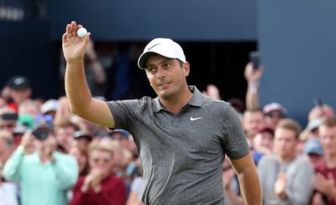 francesco molinari holds up a titleist golf ball