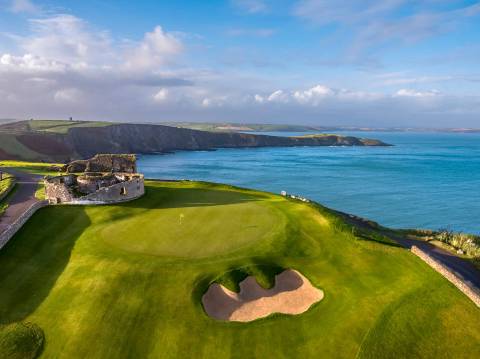 Golf course with castle ruins beside the sea in Ireland's southwest