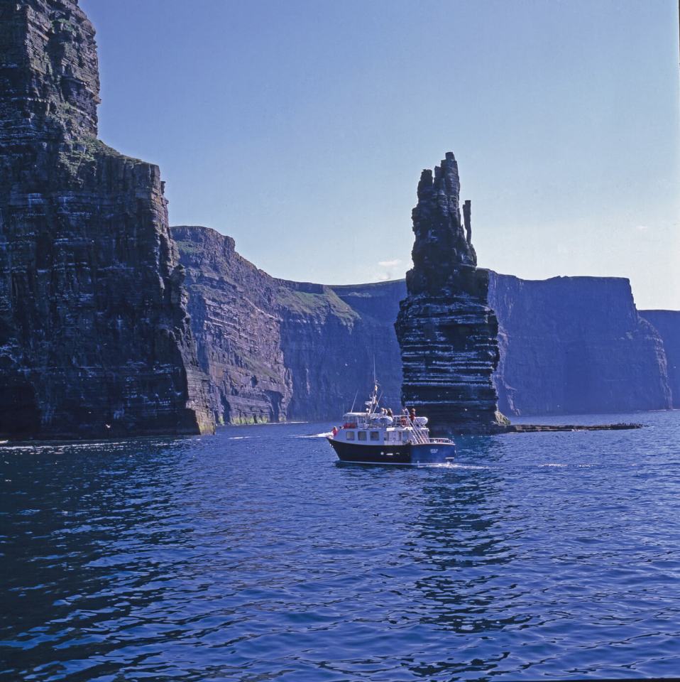 a boat approaching the cliffs of moher