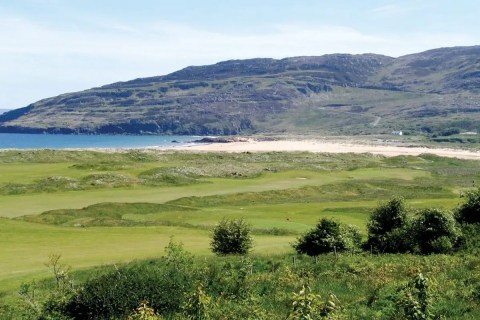 Golf course along the sunny northwest coast with coast and mountain views
