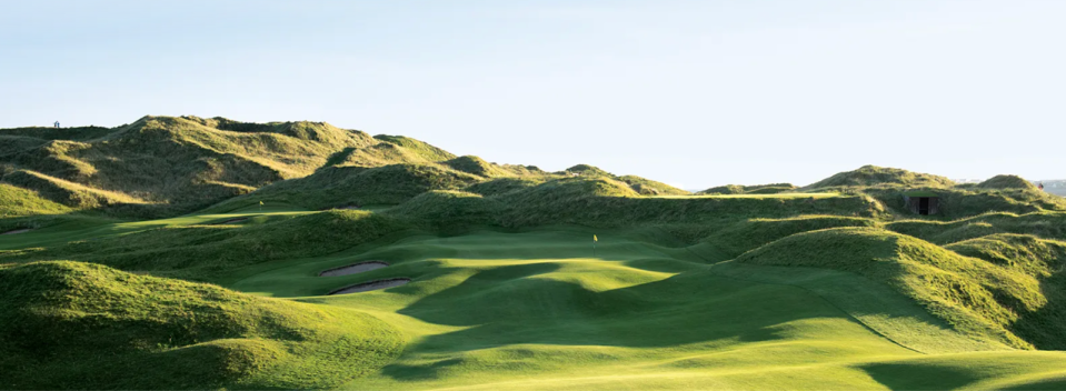 View of Lahinch Golf Course putting green with a yellow flag on the putting green centred in the image