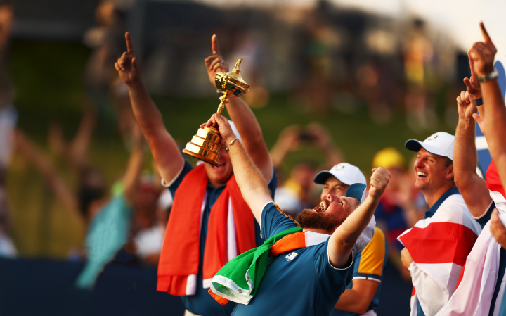 Shane Lowry celebrating a win holding a gold trophy