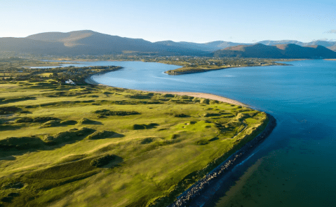 View of golf course on the sea with mountains in the background